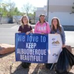 3 people holding a sign reading We Love to Keep Albuquerque Beautiful