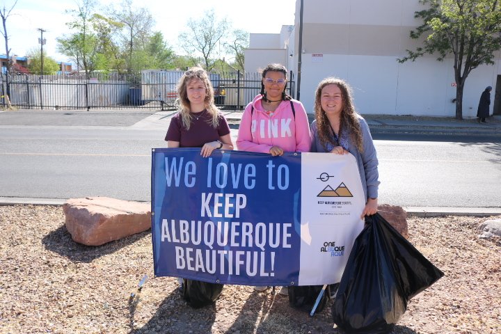 3 people holding a sign reading We Love to Keep Albuquerque Beautiful