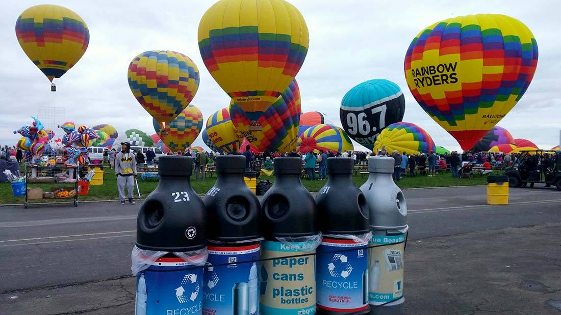 Recycling containers at balloon fiesta with balloons launching in the background