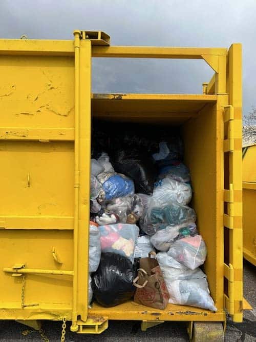 Yellow container full of recycled clothes